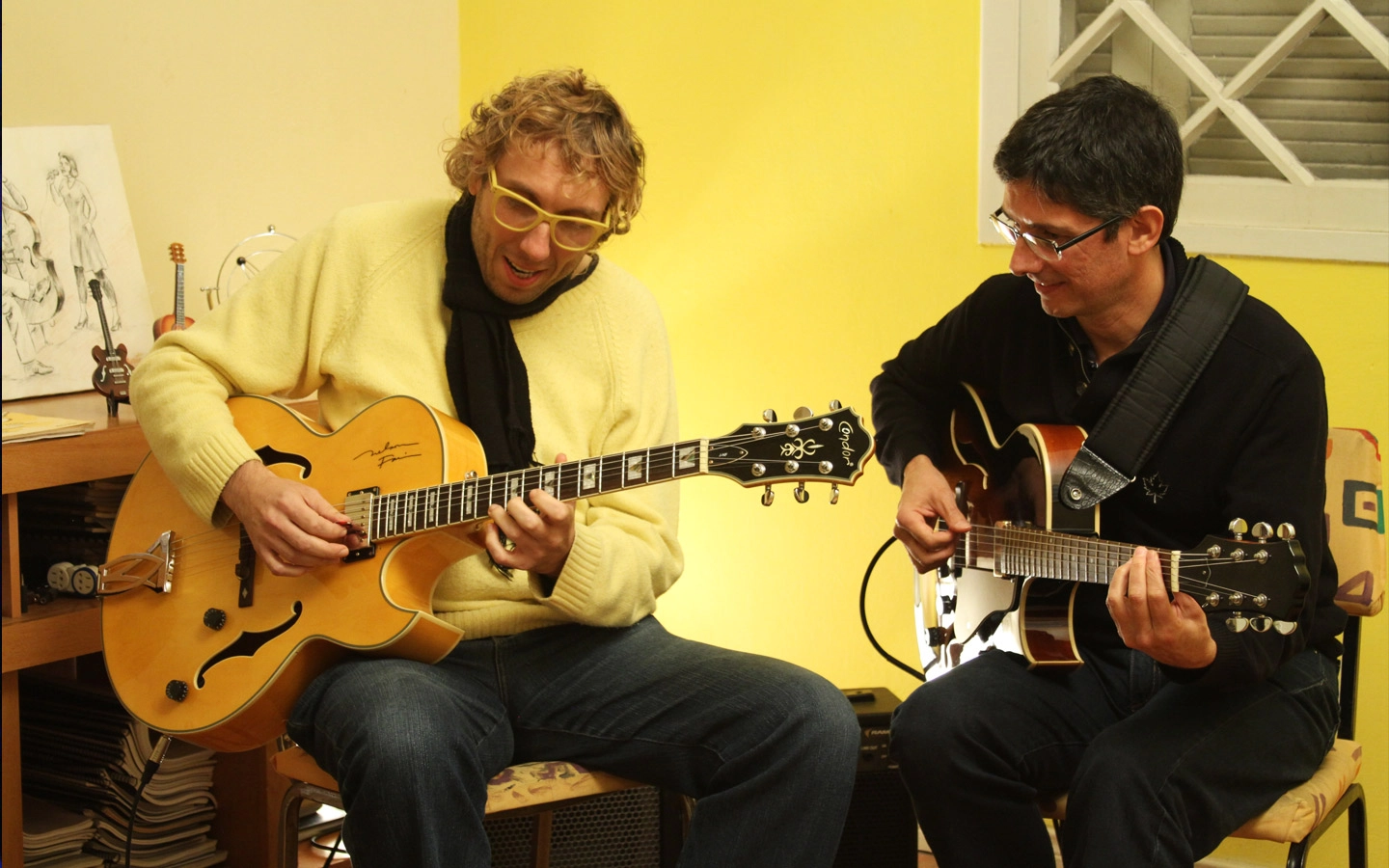 Dois homens tocando violo.