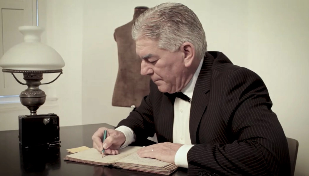 Senhor escrevendo em livro.